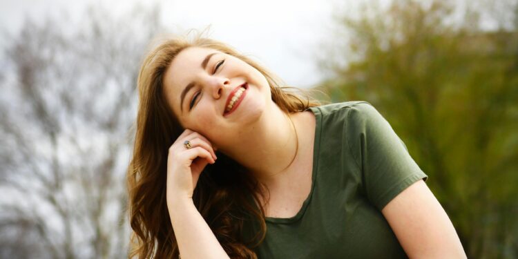 A carefree woman enjoying a sunny day outdoors, expressing pure happiness and relaxation.